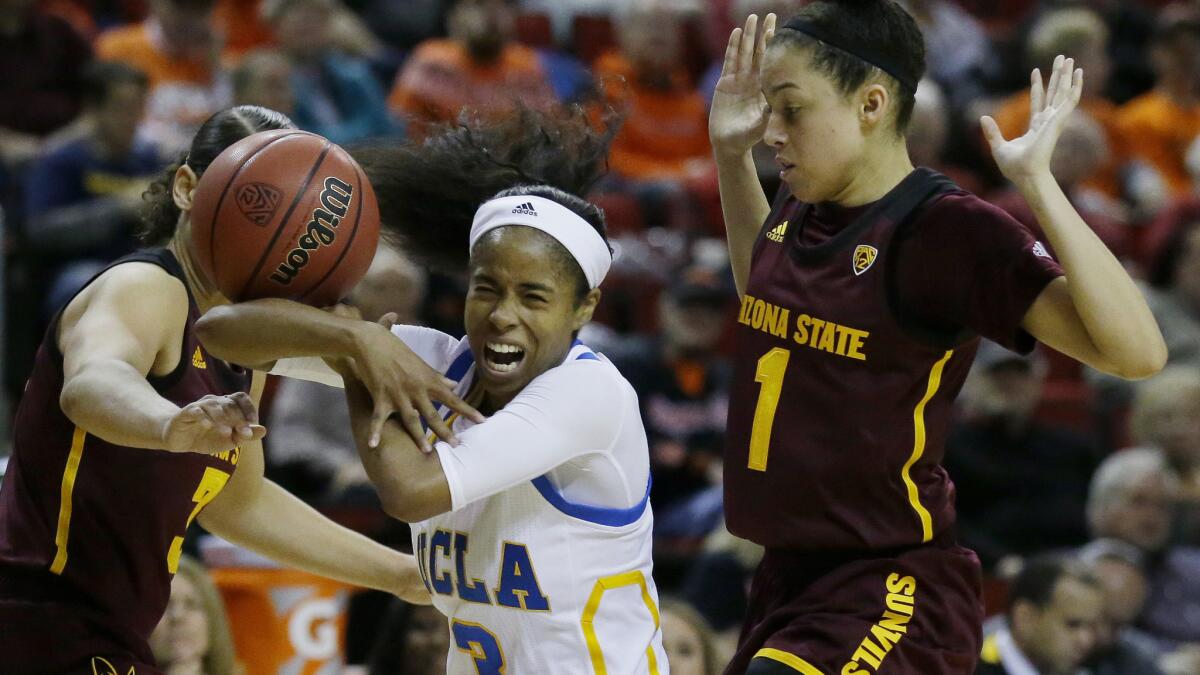 UCLA guard Jordin Canada is fouled as she drives between Arizona State guards Reili Richardson (1) and Sabrina Haines (3) during the first half Friday.