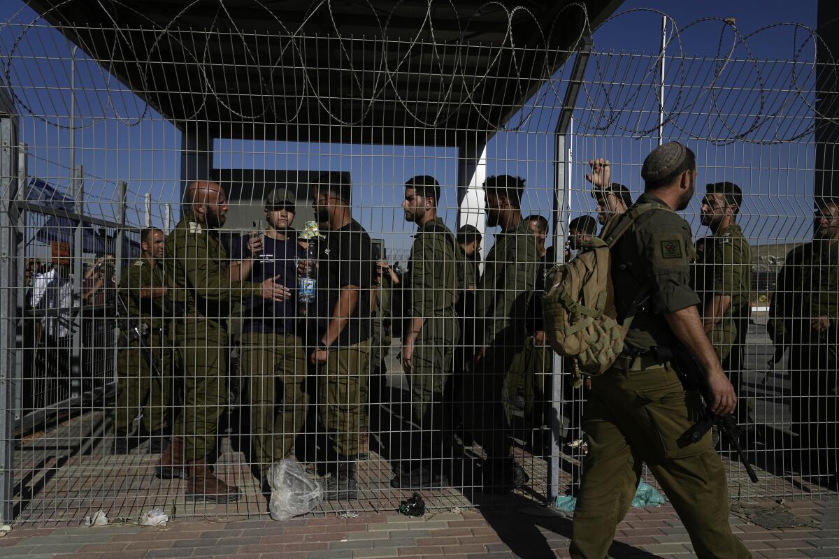 Israeli soldiers gather at the gate to the Sde Teiman military base