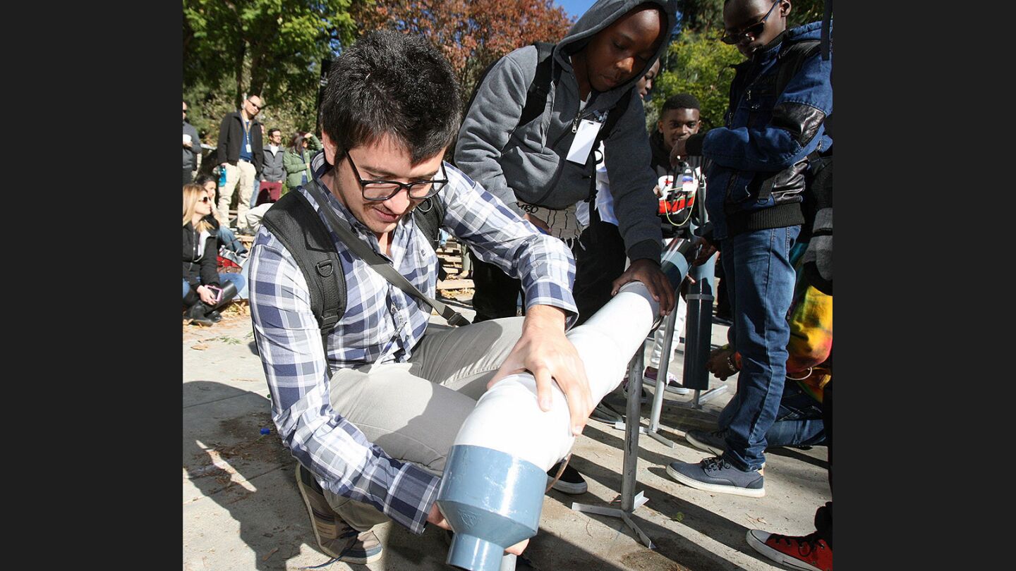 Tanzania team advisor Dogan Aykurt helps to set up his team's invention at JPL's annual Invention Challenge on Friday, December 2, 2016. 28 teams, including a team from Tanzania, but mostly of local Southern California schools, competed. The challenge was to transfer a specific amount of water over a distance to a collection cup on the other side. Methods included catapults, conveyor belts, a lot of duct tape, and pvc.