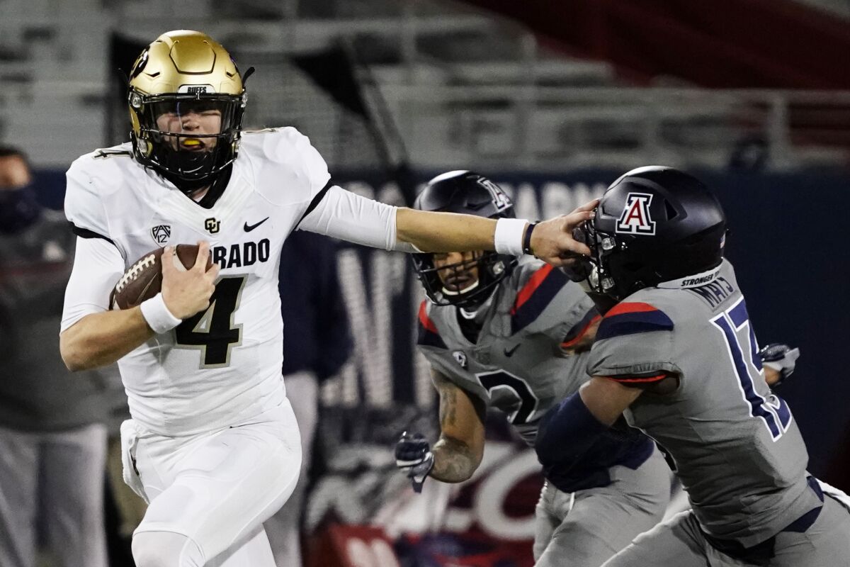 Colorado quarterback Sam Noyer (4) stiff-arms Arizona defensive back Isaiah Mays (13) in the second half during an NCAA college football game, Saturday, Dec. 5, 2020, in Tucson, Ariz. (AP Photo/Rick Scuteri)