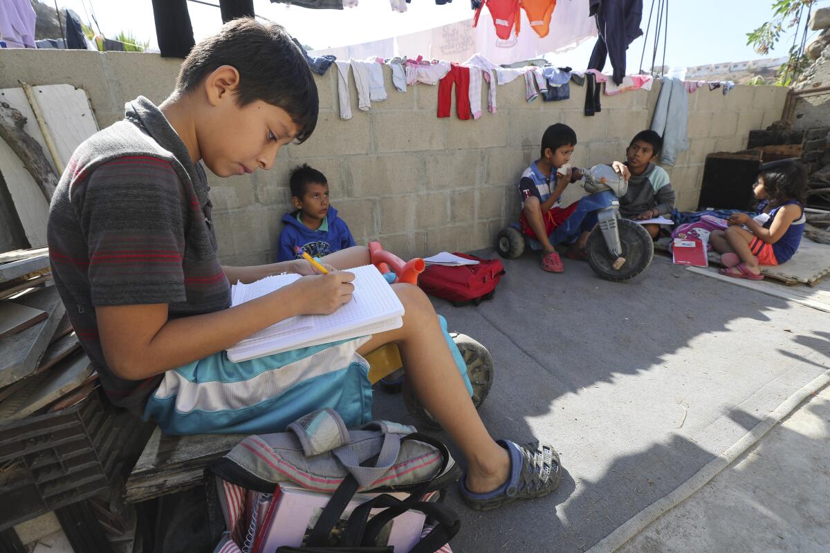 Carlos Jefferson, de 12 años, originario de Honduras, trabaja en matemáticas mientras él y otros niños estudian en el hogar en Tu Casa, un refugio para migrantes centroamericanos, en Tijuana, México, el jueves 14 de noviembre de 2019.