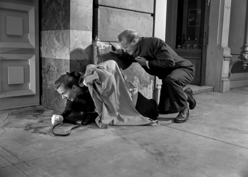 In the third photo in a four-photo sequence, actors drop to the ground, shielding as much of their bodies as possible against an atomic bomb blast.