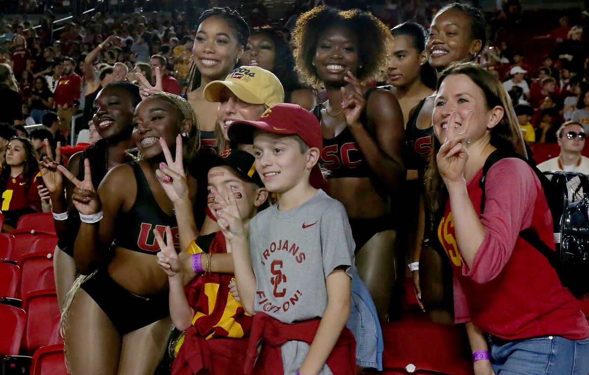 The Cardinal Divas pose for pictures with USC fans before a game against Arizona State on Oct. 1 at the Coliseum.