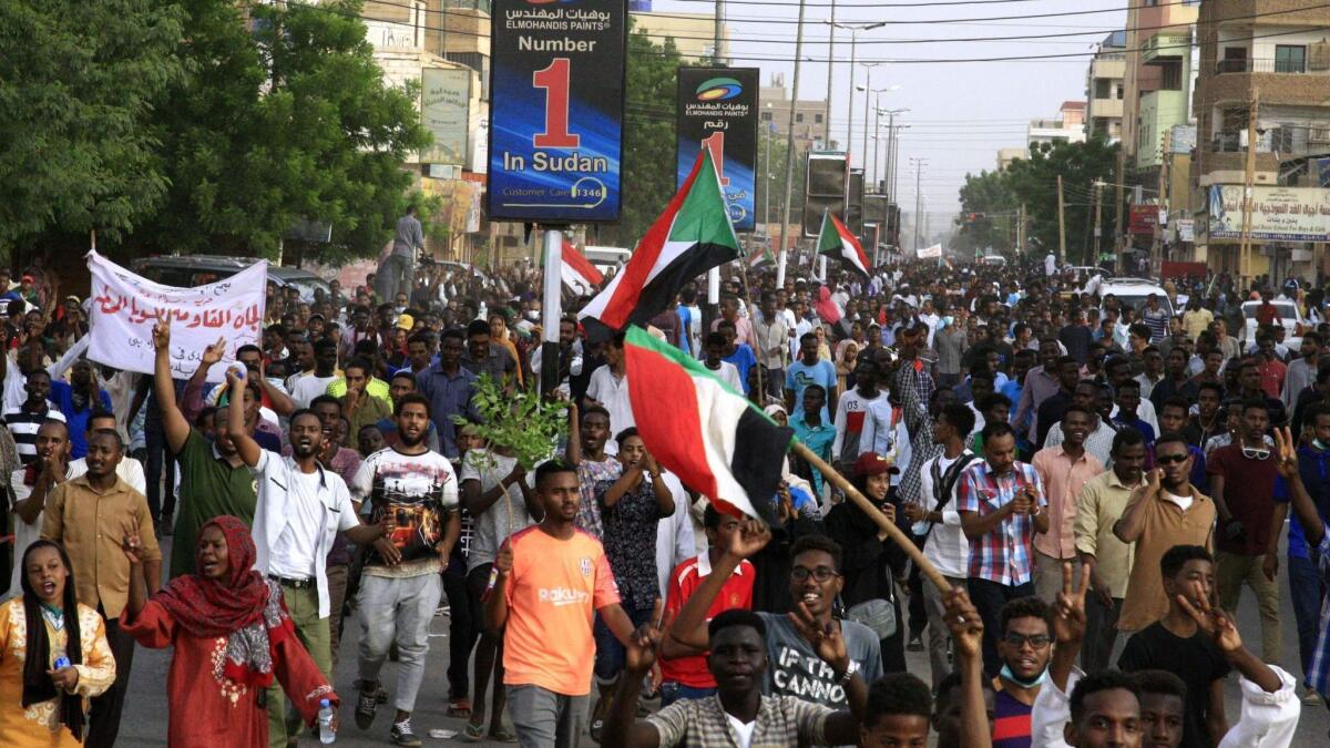 Sudanese protesters march with national flags during a mass demonstration against the country's ruling generals in the capital, Khartoum, on June 30, 2019.