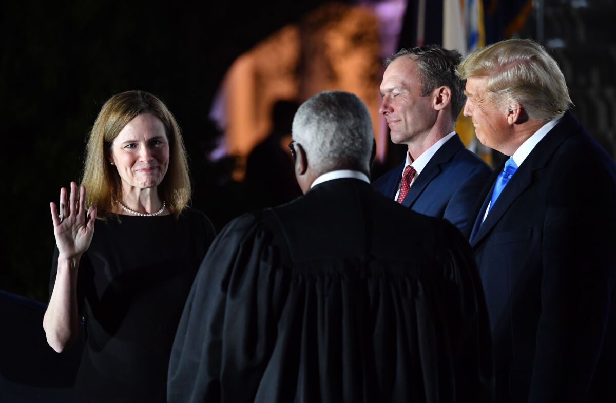 President Trump watches as Amy Coney Barrett takes an oath.