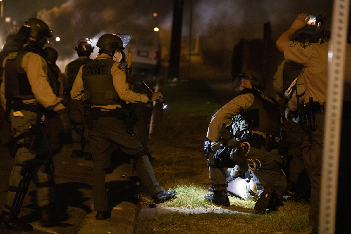 Sheriff's deputies detain a protester.