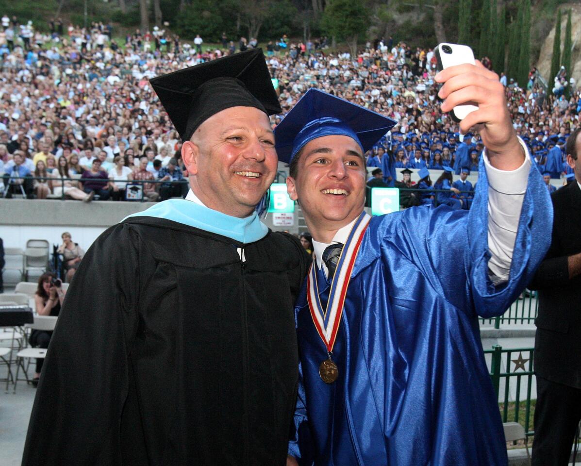 Armen Araradian holds out his cell phone to take a selfie with Principal Michael Bertram at graduation at the Starlight Bowl in Burbank on Friday, May 30, 2014. (Tim Berger/Staff Photographer)