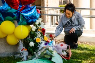 Cudahy, CA - February 13: A community member is lights a candle at a memorial outside of Ellen Ochoa Learning Center where a deadly shooting killed a boy on Tuesday, Feb. 13, 2024 in Cudahy, CA. (Jason Armond / Los Angeles Times)