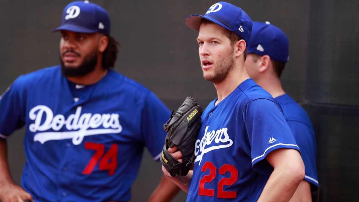 Dodgers starting pitcher Clayton Kershaw (22) stands with relief pitcher Kenley Jansen (74) and starting pitcher Rich Hill during workouts at the team's spring training baseball facility Wednesday, Feb. 14, 2018, in Glendale, Ariz.