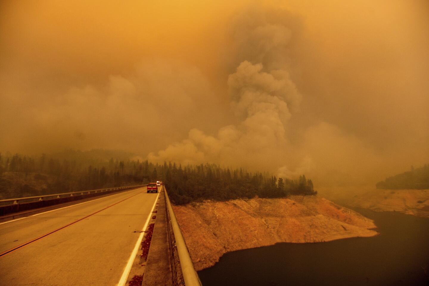 A plume rises from the Bear fire as it burns along Lake Oroville in Butte County