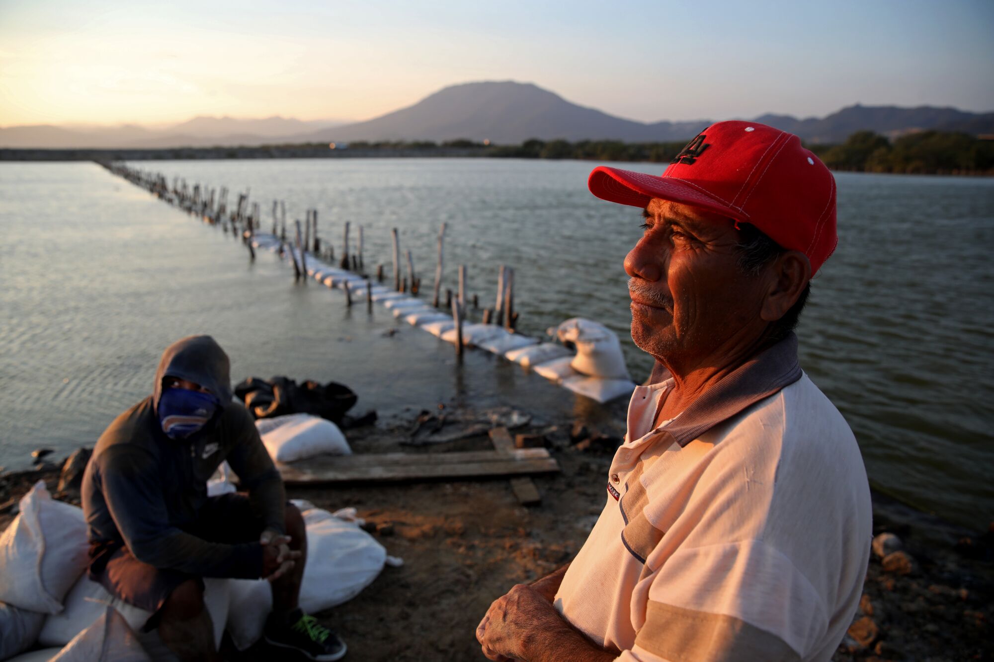 A man and his son pause while working on the water.