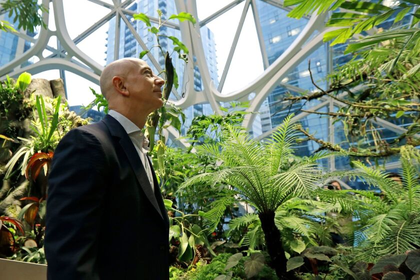 Jeff Bezos, the CEO and founder of Amazon.com, takes a walking tour of the Amazon Spheres, three plant-filed geodesic domes that serve as a work- and gathering place for Amazon employees, following a grand opening ceremony, Monday, Jan. 29, 2018, in Seattle. (AP Photo/Ted S. Warren)