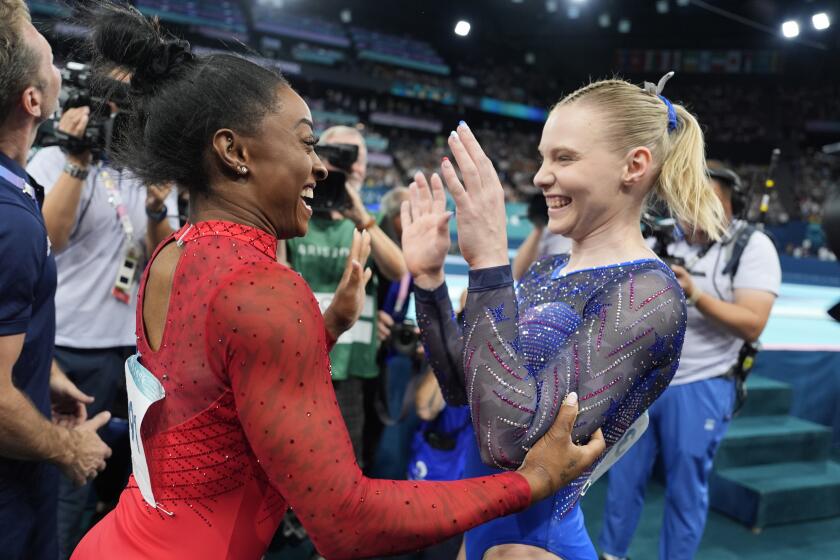 Simone Biles, left, celebrates after winning the gold medal along with bronze medalist.