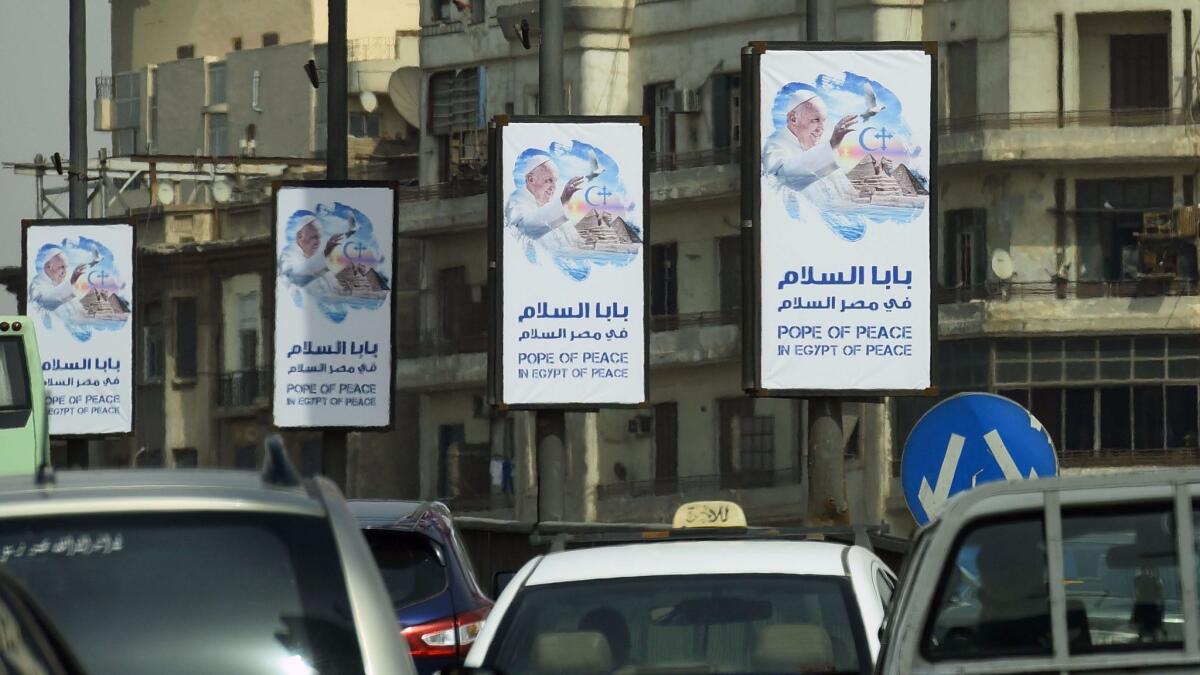 Welcome banners bear a portrait of Pope Francis ahead of his visit to Egypt.