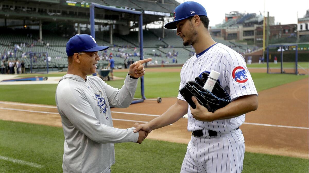 Dodgers manager Dave Roberts, left, visits Chicago Cubs starting pitcher Yu Darvish before a baseball game between the two clubs June 20, 2018, in Chicago.