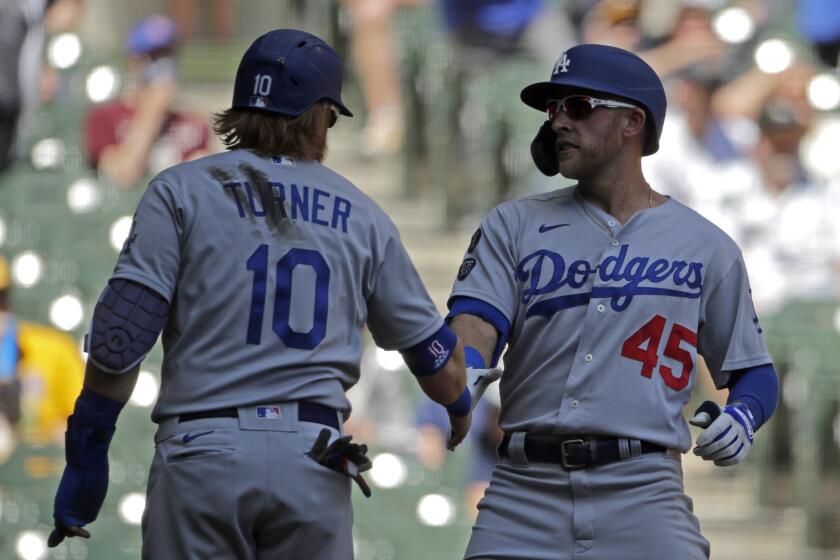 Los Angeles Dodgers' Matt Beaty, right, is congratulated by Justin Turner, left, after hitting a grand slam.