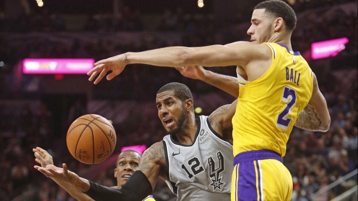 San Antonio Spurs' LaMarcus Aldridge (12) battles Lakers' Lonzo Ball (2) for a rebound at AT&T Center on Saturday in San Antonio.