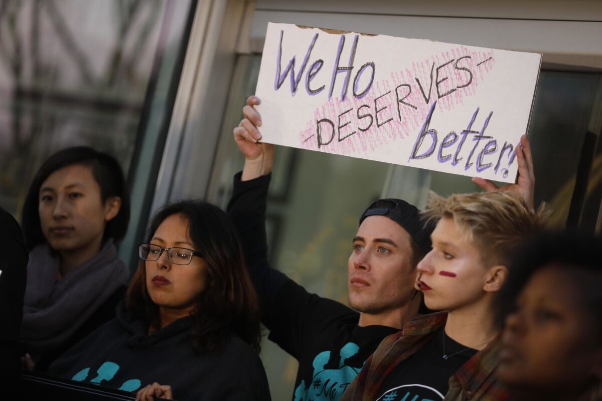 West Seegmiller, holding sign, joins others outside the West Hollywood City Council chambers to call on West Hollywood Mayor John Duran to resign amid allegations of sexual harassment.