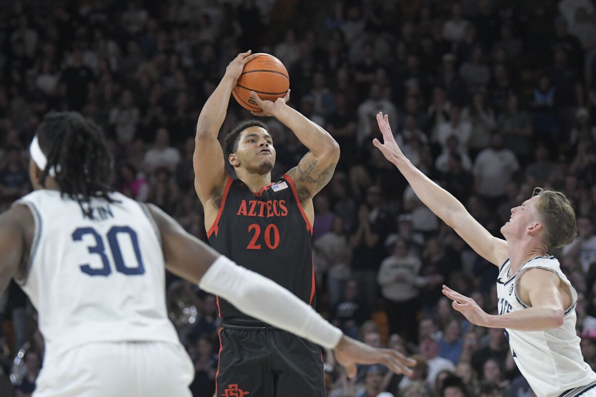 Aztecs guard Matt Bradley shoots the ball as Utah State guard Sean Bairstow defends. Bradley finished with 18 points.