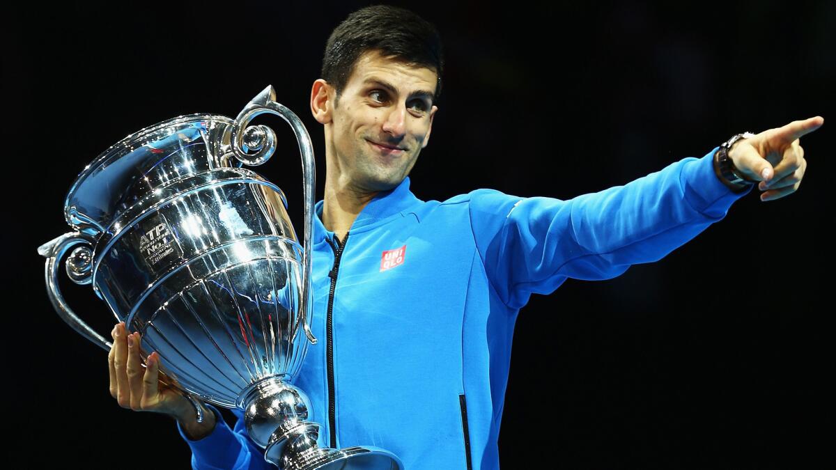 Novak Djokovic celebrates with the ATP World Tour No. 1 Trophy after he defeated Kei Nishikori on Sunday in London.