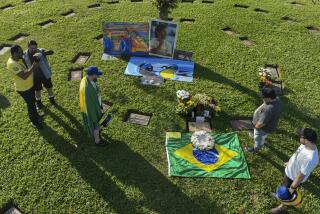 Aficionados se reúnen en la tumba del fallecido piloto brasileño Ayrton Senna al recordar el 30mo aniversario de su muerte, en el cementerio de Morumbí en Sao Paulo, el 24 de mayo de 2024. (AP Foto/Andre Penner)