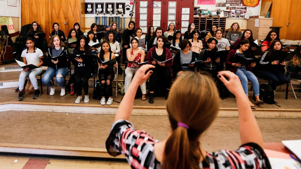 Choir director Brianne Arevalo guides students through rehearsal for "Hear Our Voice."