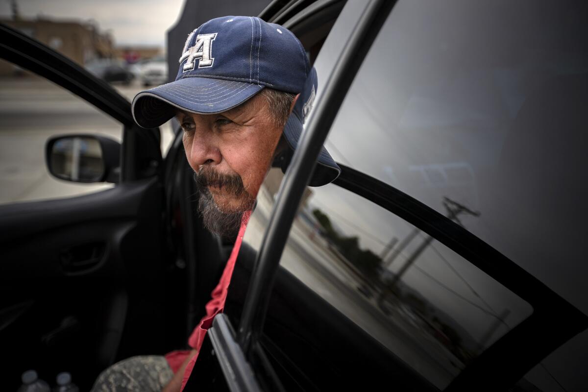 Jesus Lara, 61, waits for work sitting in his car in a shopping plaza parking lot in Mecca. (Irfan Khan / Los Angeles Times)