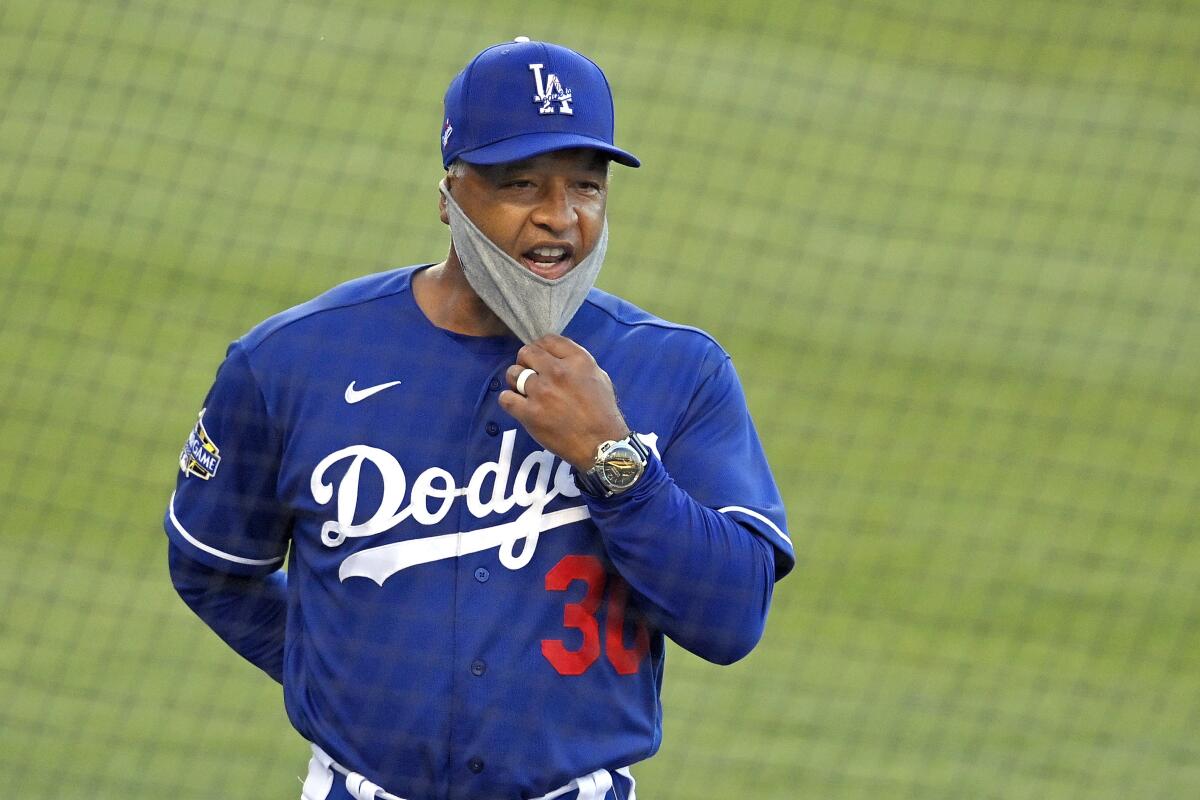 Dodgers manager Dave Roberts pulls down his mask.