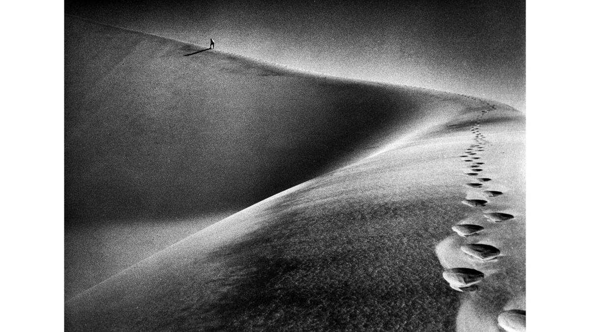 Oct. 16, 1976: Jack Hereford, in far background, makes his way up a ridge of the Kelso Dunes in the Mojave Desert during an investigation of mysterious sounds emanating there.