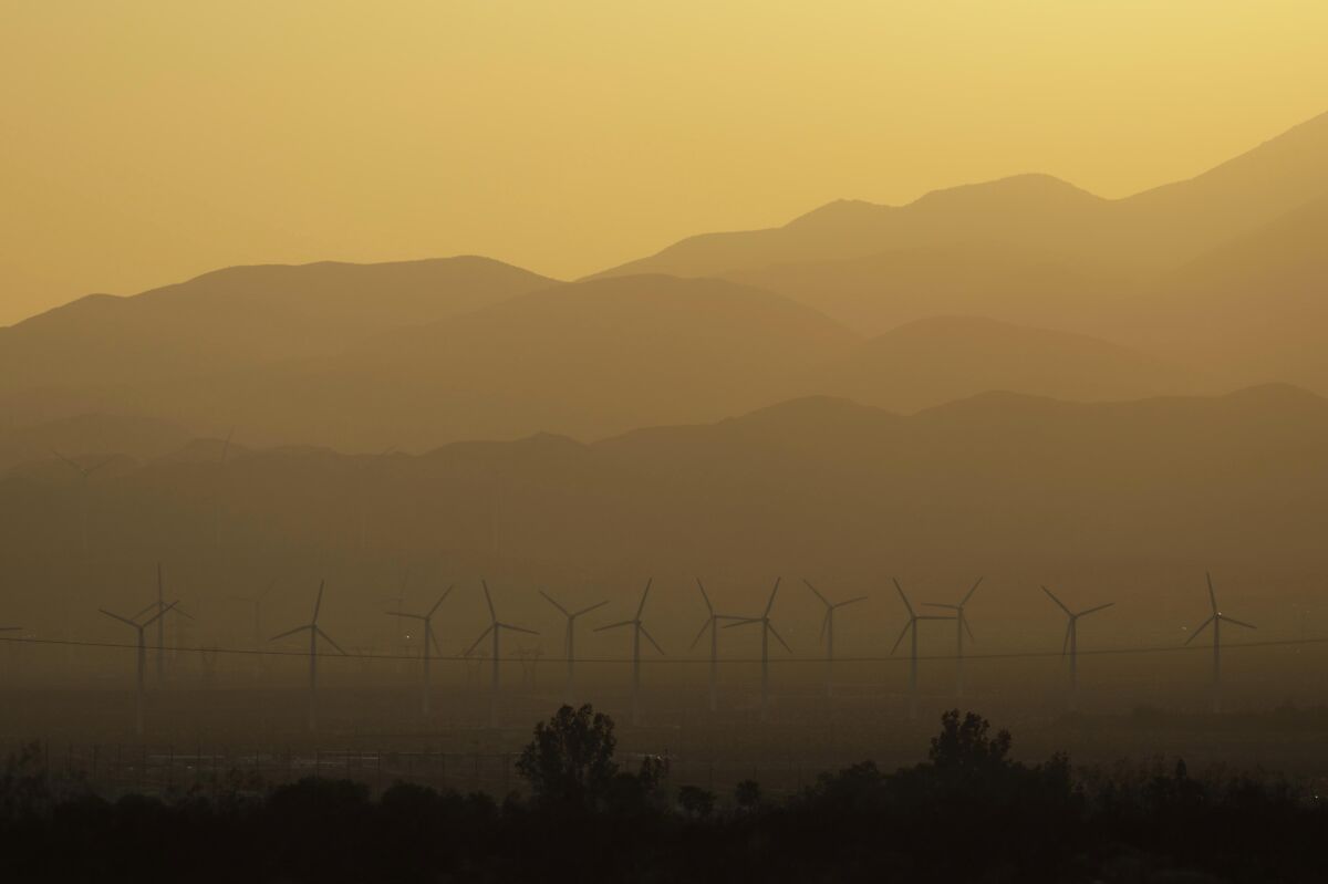 The sun sets over wind turbines in the Coachella Valley in July 2021.