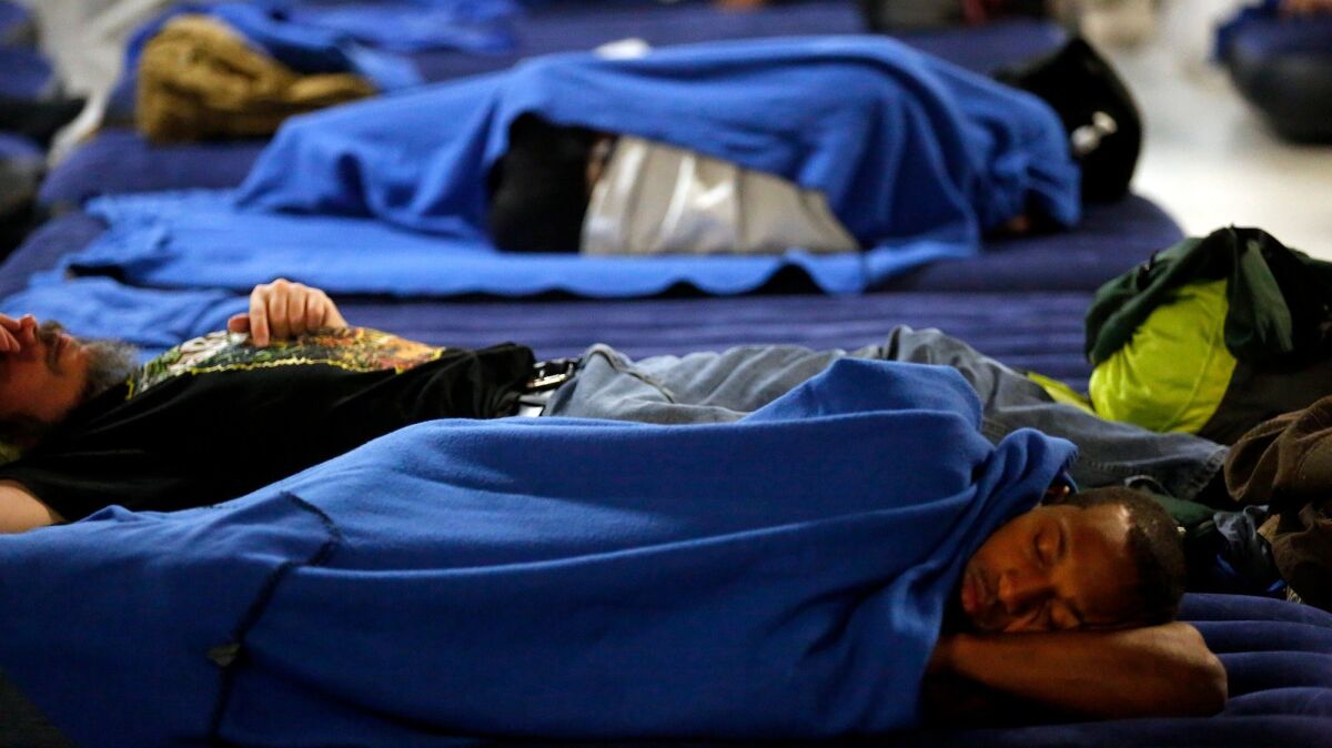 Men sleep on air mattresses in the overcrowded Union Rescue Mission.