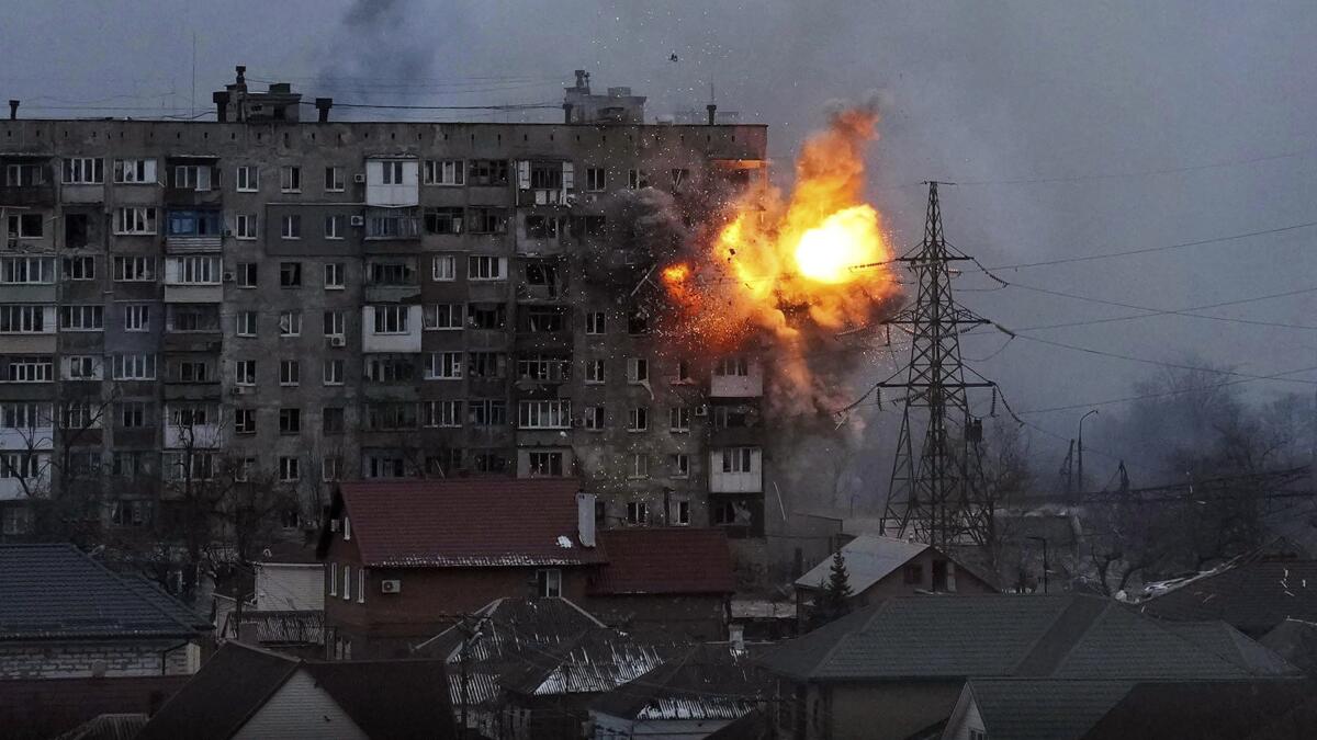 An explosion erupts from an apartment building after a Russian army tank fired on it in Mariupol.