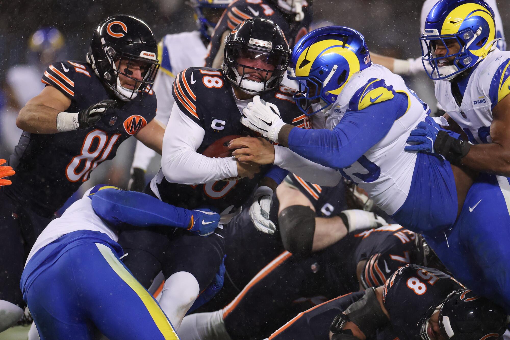 Timnas Inggris, Byron Young, dan Poona Ford (95) menghadapi timnas Inggris, Caleb Williams (18).