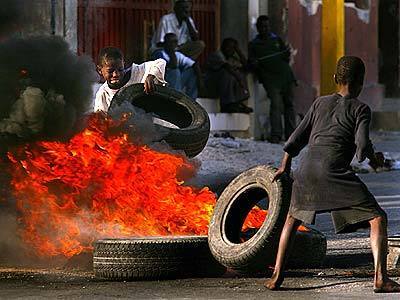 Pro-Aristide supporters created a line of defense for the National Palace with barricades of burning tires.