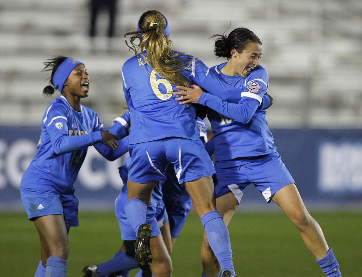 Kodi Lavrusky, right, celebrates with UCLA teammates Lauren Kaskie, center, and Taylor Smith after scoring the winning goal against Florida State to win the NCAA women's soccer championship on Dec. 8, 2013.