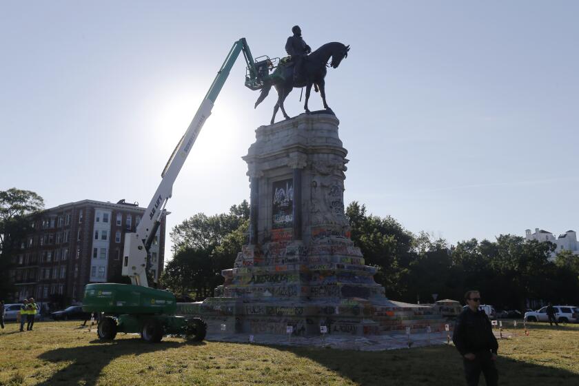 EDS NOTE: OBSCENITY - An inspection crew from the Virginia Department of General Services inspect the statue of Confederate Gen. Robert E. Lee on Monument Avenue Monday June. 8, 2020, in Richmond, Va. Virginia Gov. Ralph Northam has ordered the removal of the statue. (AP Photo/Steve Helber)