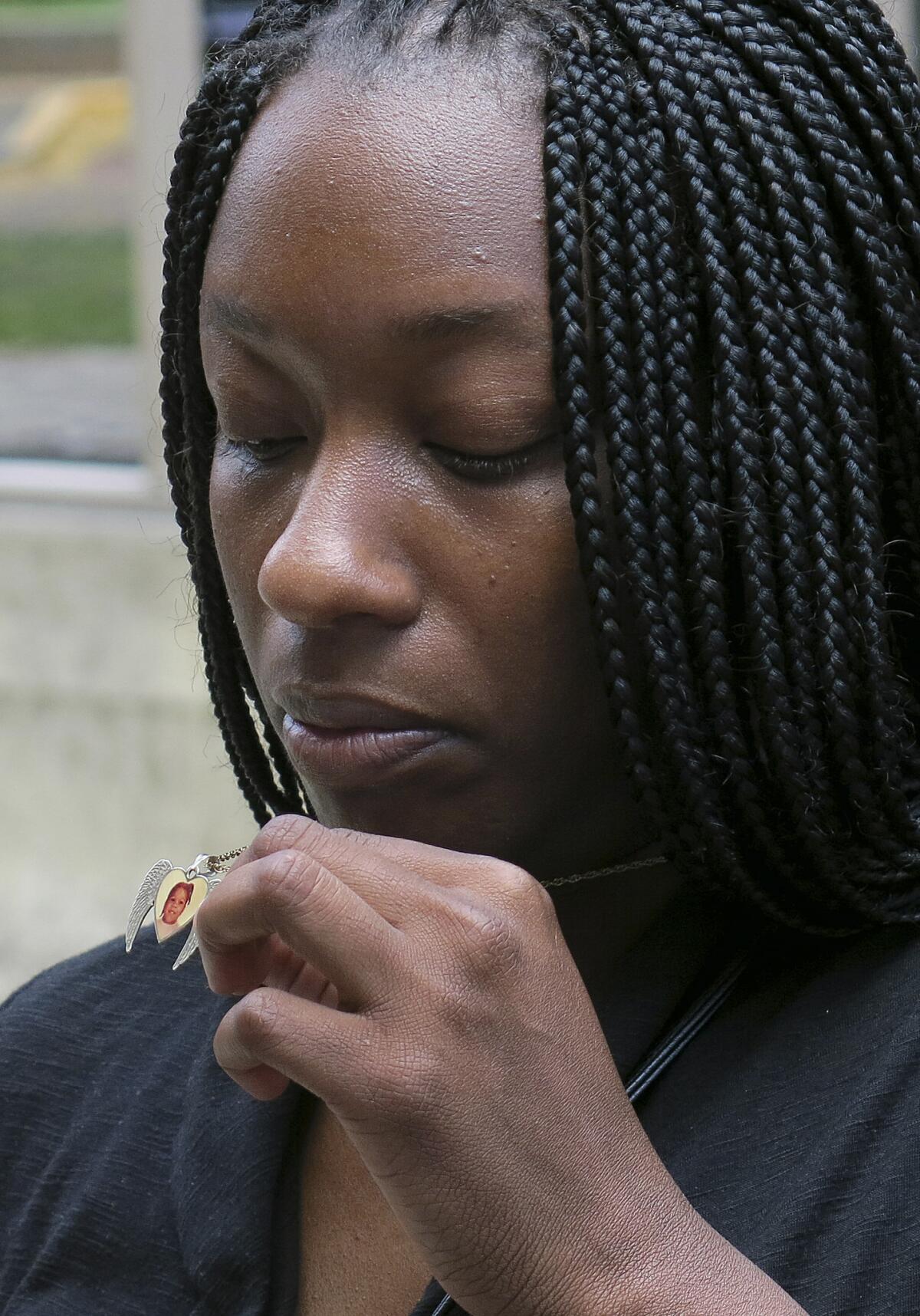 Tarshia Williams displays a pendant with her daughter's face on it outside of a federal courthouse in Honolulu on Thursday. A federal jury convicted the girl's father, former Hawaii soldier Naeem Williams, of murder in the beating death of the 5-year-old girl, a capital offense in a state that doesn't have the death penalty.