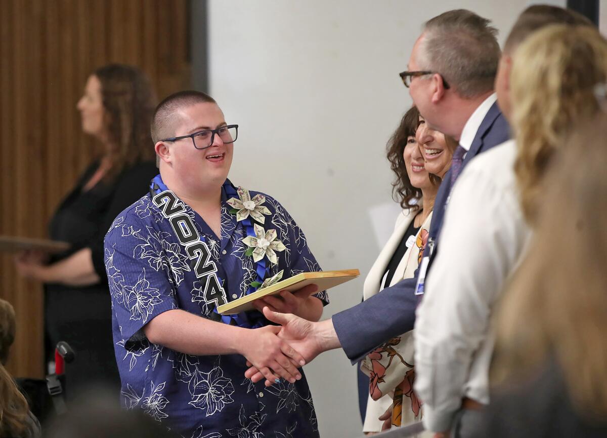 Seth Barker walks the hand-shake line after receiving his diploma from NMUSD's STEP program Wednesday in Costa Mesa.