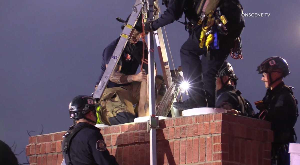 Fire crews rescued a woman who got stuck upside down in a chimney in Paradise Hills on Sunday.