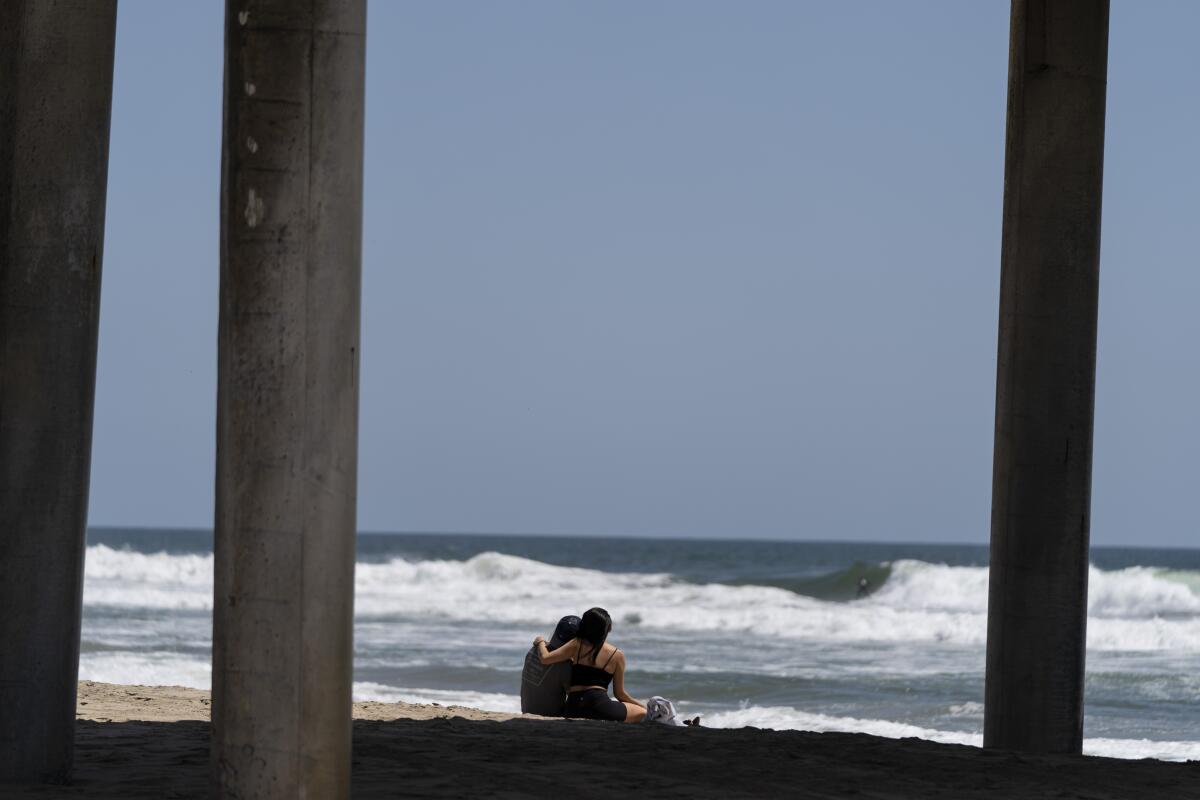 Una pareja joven descansa en la playa en Huntington Beach, California, 