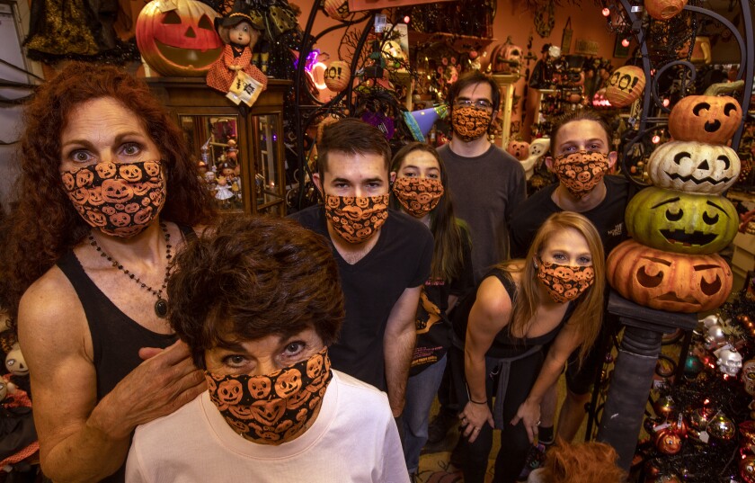 The staff at Traditions in Canoga Park gather to show off a popular new product: Halloween-themed face masks.