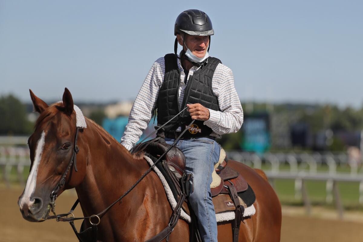 Tiz The Law trainer Barclay Tagg rides another horse on the main track during workouts at Belmont Park on Wednesday.