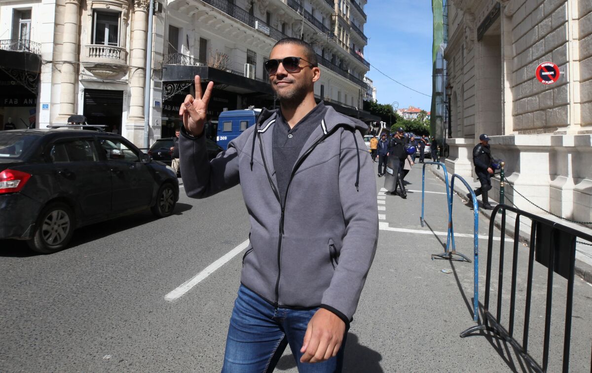 FILE - In this March 10, 2020 file photo, Algerian journalist Khaled Drareni flashes the V sign as he leaves the courthouse in Algiers. An Algerian court sentenced on Tuesday journalist Khaled Drareni to two years in prison on appeal, in a trial that rights group have denounced as violating press freedom. Drareni, editor of the Casbah Tribune news site and Algeria correspondent of RSF and the French TV channel TV5 Monde, played a prominent role in covering the country's pro-democracy movement last year.(AP Photo/Str, File)
