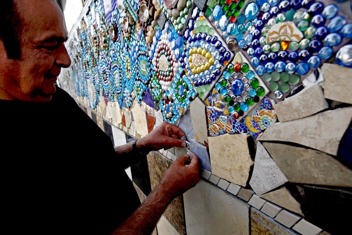 Azis Farman works on the last stretch of wall, the culmination of years of work.