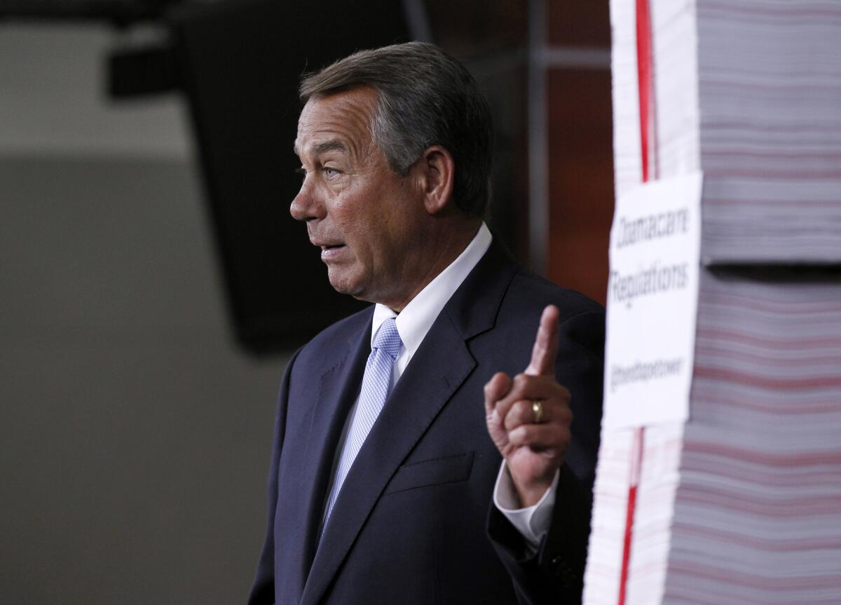 House Speaker John A. Boehner (R-Ohio) gestures toward a stack of paper representing the 20,000 pages of Affordable Health Care Act regulations during a news conference on Capitol Hill in Washington in May. Delays in issuing some of those rules led the Treasury Department to announce Tuesday that it was postponing enforcement of the law's requirement that employers provide insurance to their full-time workers.