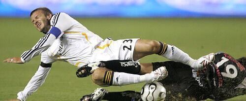 Galaxy's David Beckham collides with Pachuca's Christian Gimenez in the first half in a play before injuring his knee in the final of the SuperLiga tournament Wednesday night at the Home Depot Center.