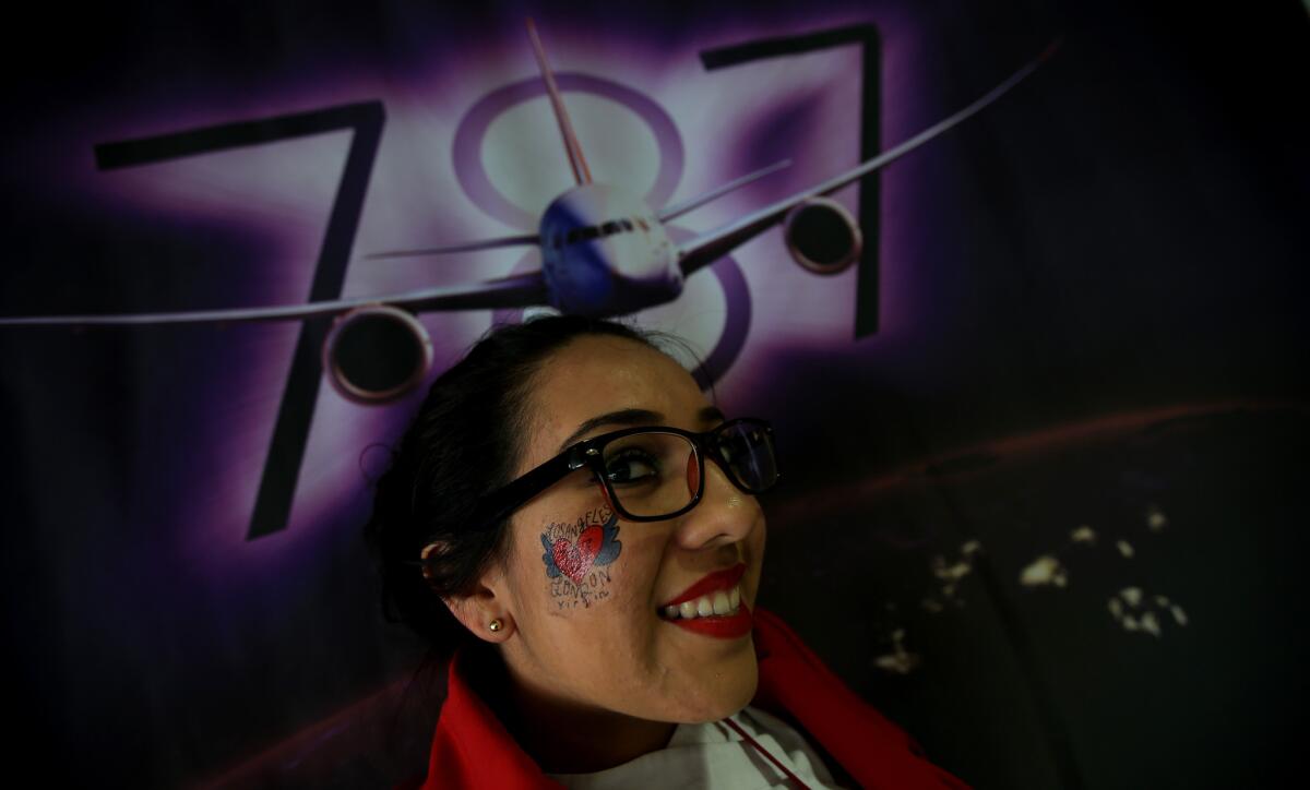 Virgin Atlantic personnel prep for the maiden flight of Birthday Girl, a new Boeing 787 that will fly from Los Angeles to London. The plane includes a spot near the back of the cabin for selfie portraits.