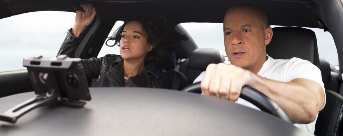 Michelle Rodriguez and Vin Diesel brace for impact in a scene from the movie "F9."