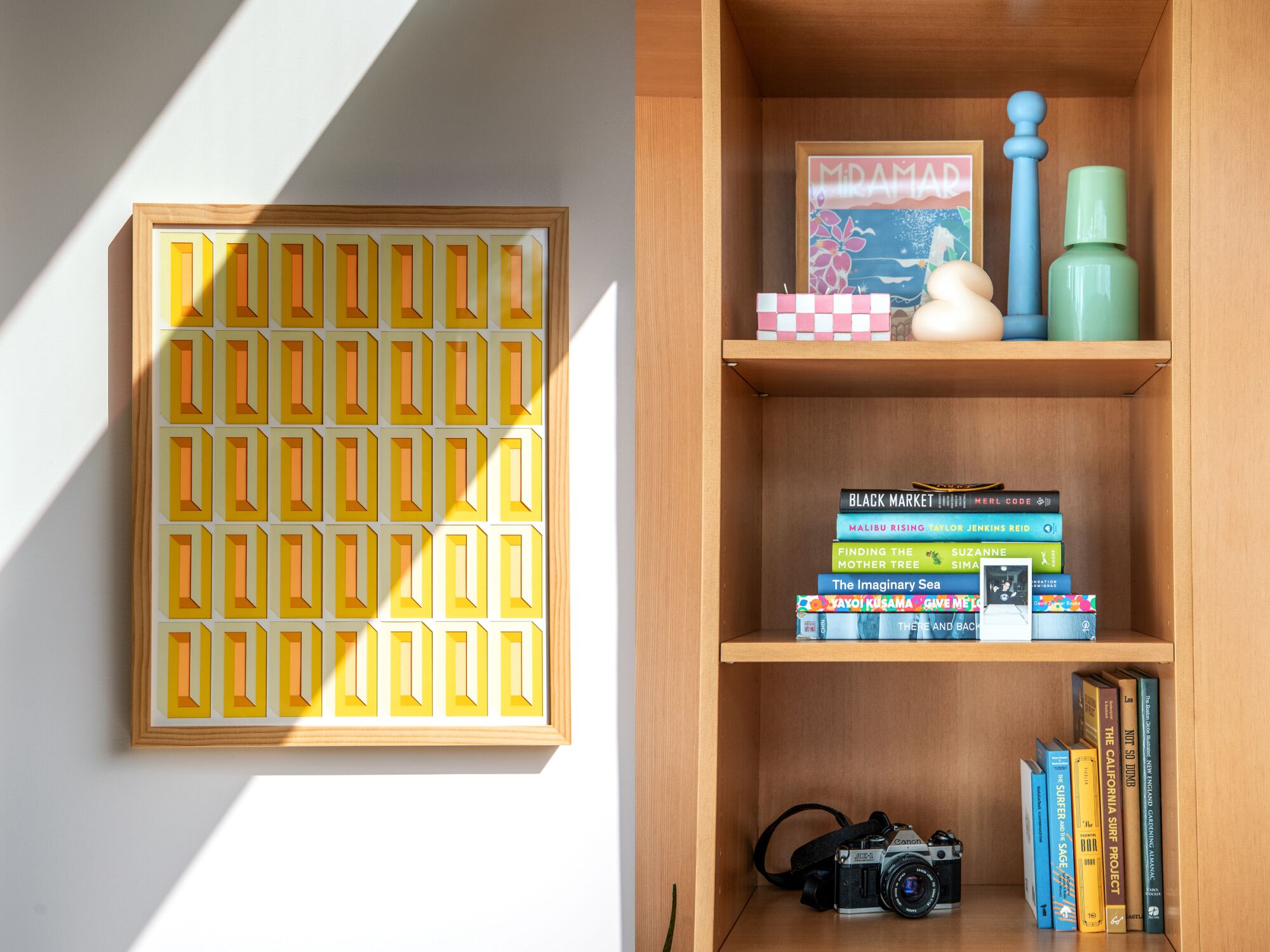 Two photos side by side showing a yellow painting on a wall, left, and books and a camera on a shelf, right.