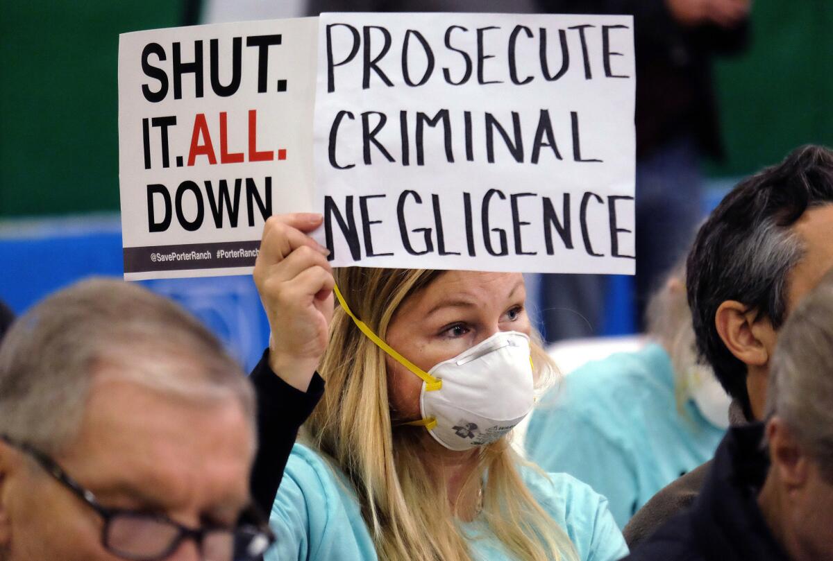 Tera Lecuona of Porter Ranch holds a protest sign during a hearing in Granada Hills over a methane leak at Southern California Gas Co.'s Aliso Canyon Storage Facility.